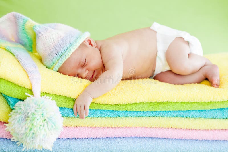 Newborn baby sleeping on color towels