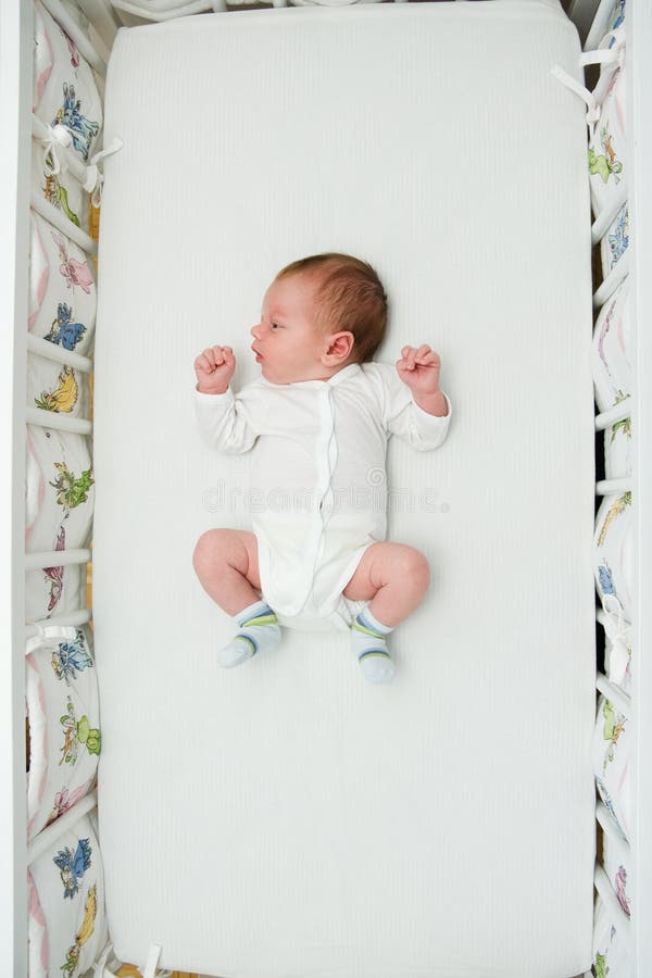 Newborn boy sleeping in big bed