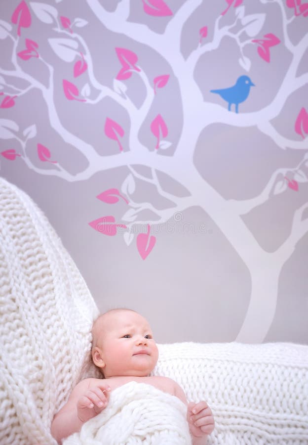 Newborn girl in cute baby room