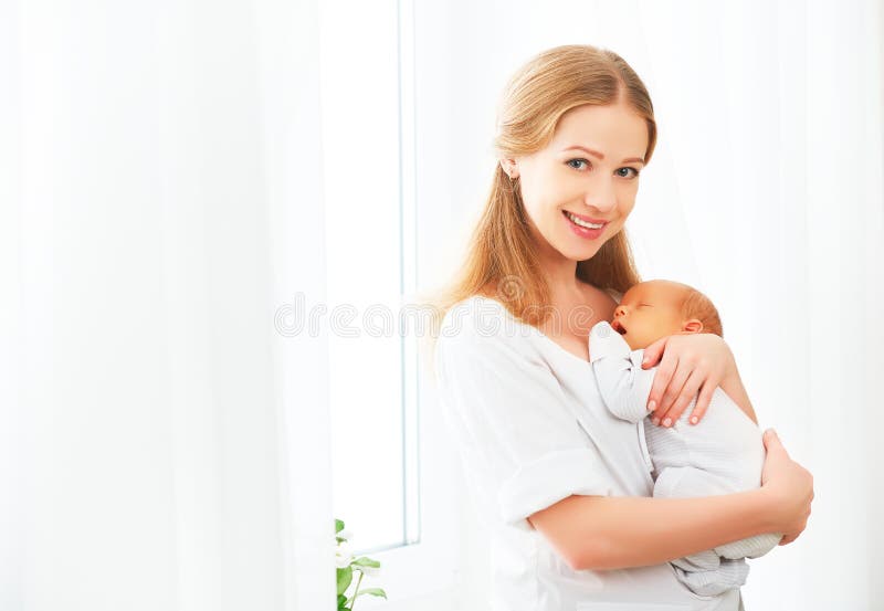Newborn младенец в нежном объятии матери стоковое фото