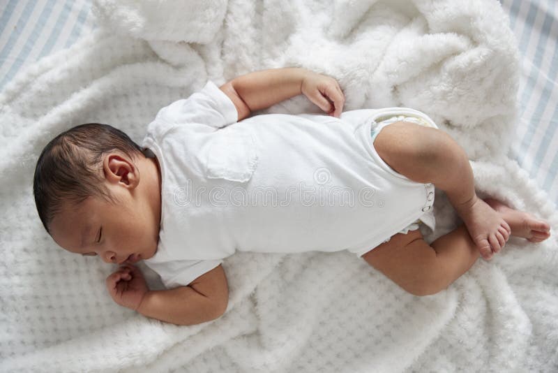 Newborn младенец спать в кроватке питомника стоковое изображение