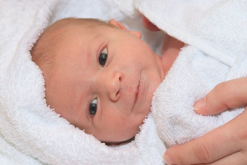 Newborn in white towel just after a bath. Newborn in white towel just after a bath