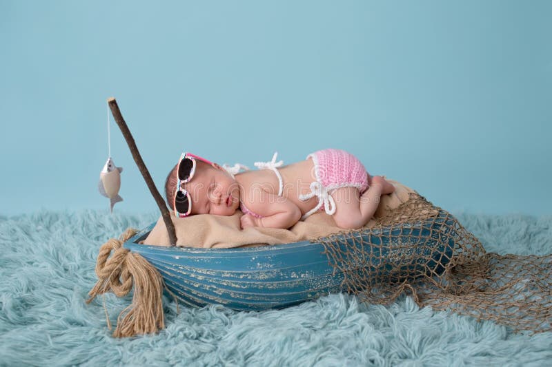 Newborn ребёнок спать в рыбацкой лодке стоковая фотография Newborn ребёнок спать в рыбацкой лодке стоковая фотография