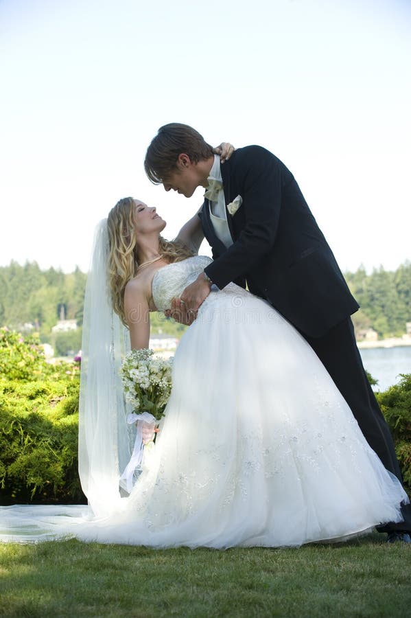 Bride and groom pose for camera on their wedding day. Bride and groom pose for camera on their wedding day