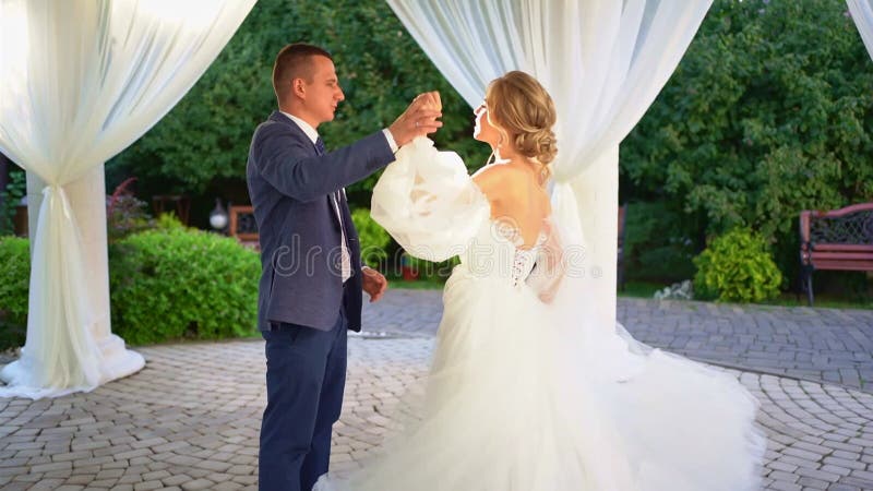 Newlyweds dansar i rotunda med vita gardiner