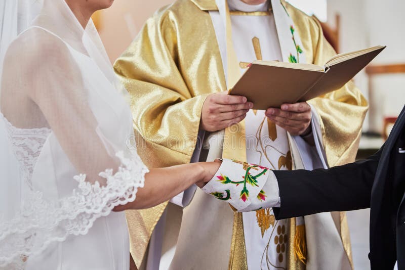 Newlyweds Hold Hands during a Wedding in a Catholic Church Stock Photo ...