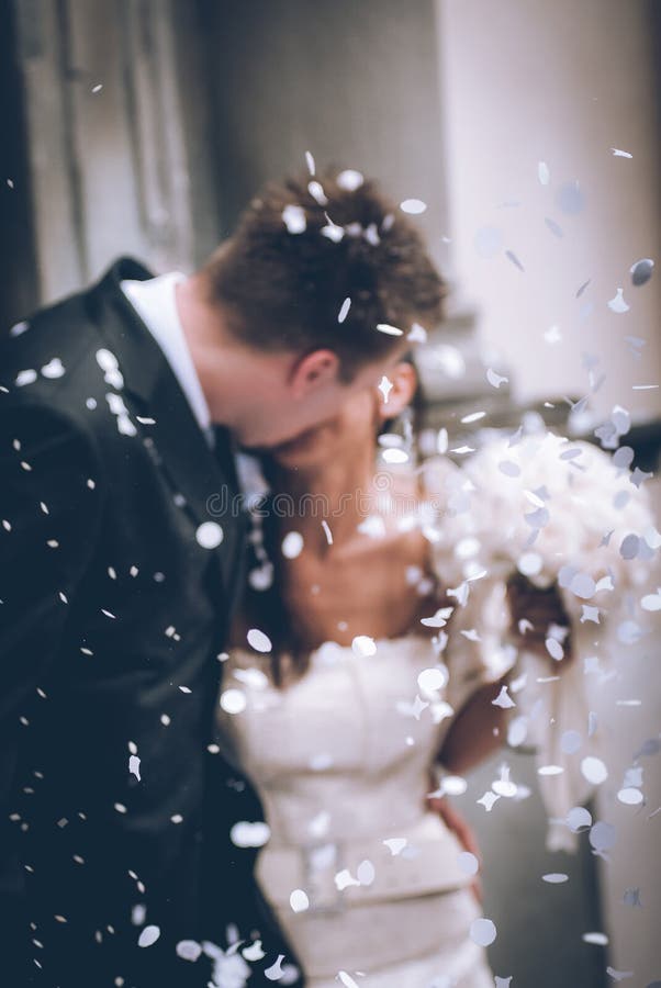 Newlyweds φιλούν - σκόπιμος η εστίαση εικόνας στο κομφετί - τις αισθητήριες συνδέσεις στοκ εικόνα με δικαίωμα ελεύθερης χρήσης