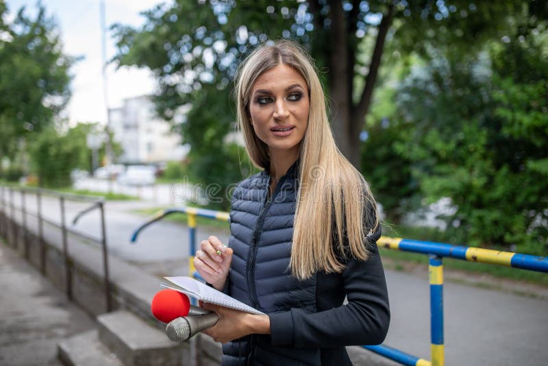 News reporter or TV journalist at press conference, holding microphone and writing notes stock photography