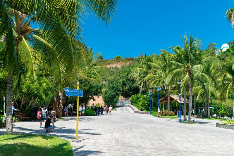 NHA TRANG, VIETNAM - 16 APRILE 2019: Turisti nel parco di divertimenti sotto gli alberi tropicali in Vinpearl in Nha Trang fotografia stock libera da diritti NHA TRANG, VIETNAM - 16 APRILE 2019: Turisti nel parco di divertimenti sotto gli alberi tropicali in Vinpearl in Nha Trang fotografia stock libera da diritti