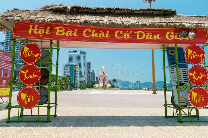 NHA TRANG, VIETNAM - APRIL 21, 2019: Gate with a red inscription on the beach and lotus monument in the distance in the tropics. NHA TRANG, VIETNAM - APRIL 21, 2019: Gate with a red inscription on the beach and lotus monument in the distance in the tropics