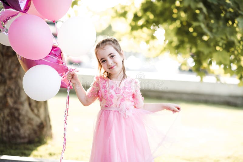 Una Niña De 4 Año De Edad En Pie Y Mirando La Cámara Mientras Que Jugando  Con Algunos Globos Multicolores. Fotos, retratos, imágenes y fotografía de  archivo libres de derecho. Image 8060540