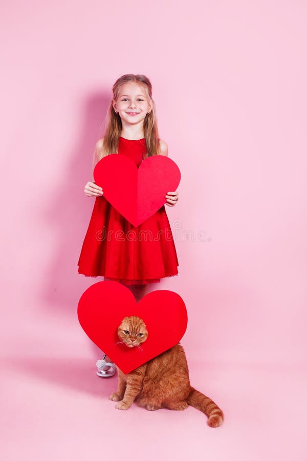 Niña Feliz Con Vestido Rojo Y Gato Rojo Con Un Corazón De Papel Con Fondo  Rosa Imagen de archivo - Imagen de retrato, felicidad: 169203659