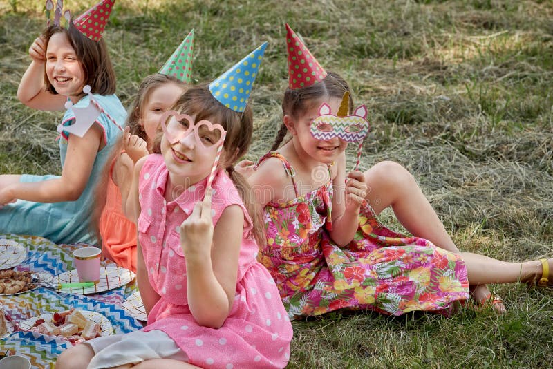 Niñas Celebran En Carnaval Máscaras Sombreros De Fiesta. Divertidos Picnic Con Amigos. Foto - Imagen de disfrute, cubo: 205054264