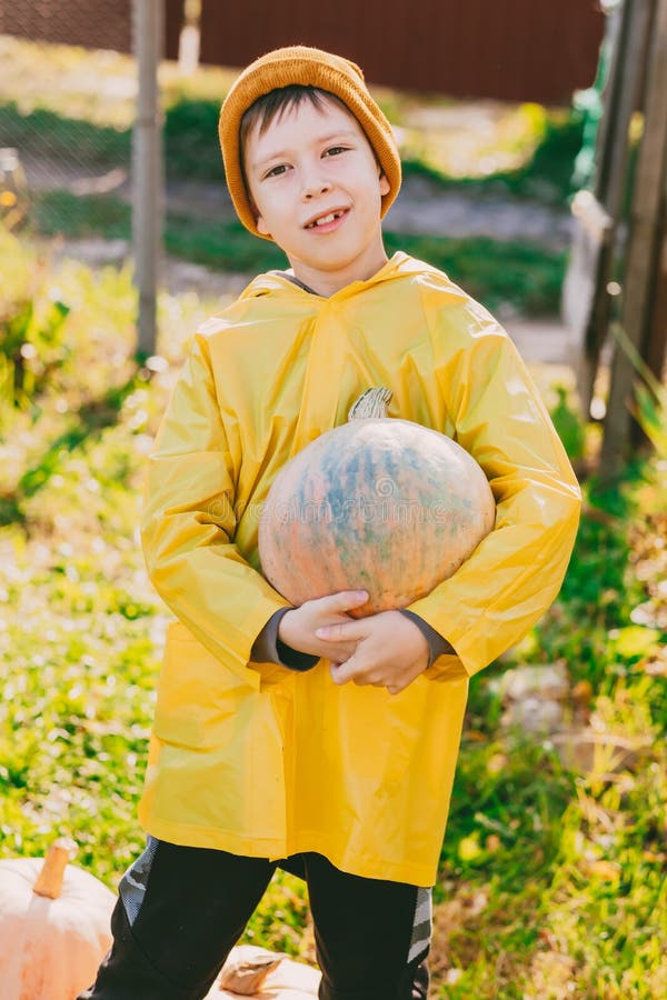 Un Niño Con Impermeable Amarillo Sale a La Lluvia. Solo Un Niño Camina Bajo  La Lluvia. Vista Posterior En Un Impermeable Brillante Imagen de archivo -  Imagen de cabritos, charco: 224329095