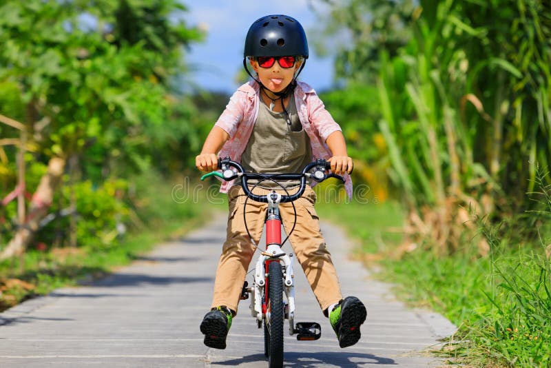 Niño Jinete Joven En Casco Y Gafas De Sol Montar En Bicicleta Foto