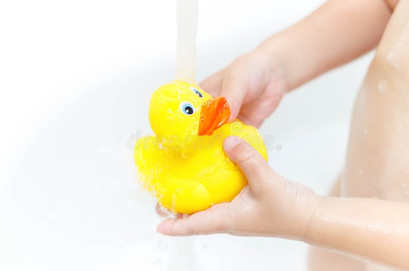 Patito de goma amarillo en espuma de jabón. juguete de baño para bebés.