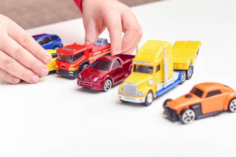 Niño Jugando El Niño Juega Con Los Coches De Juguete Cerca De Las Manos Imagen de archivo - Imagen de cerca, niño: 159533313