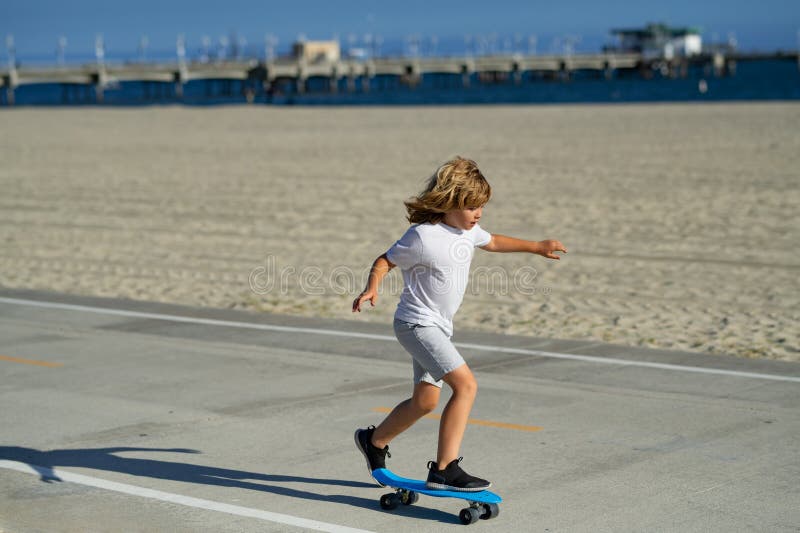 Niños deportivos de verano con skateboard. Niño montando