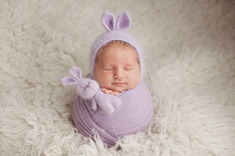 Lindo Recién Nacido Durmiendo En Una Manta. Bebé Recién Nacido Con Sombrero  De Conejo Con Orejas. Bebé Con Traje De Conejito De Punto. Nacimiento Y  Cuidado Del Niño. Ropa De Lana Caliente