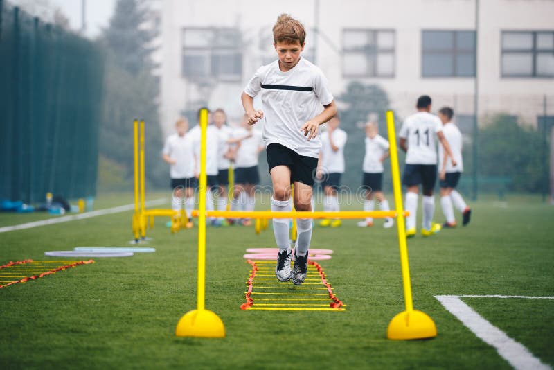 Niños En Entrenamiento De Agilidad En El Campo De Fútbol Escolar.  Futbolista Atleta En Entrenamiento Imagen de archivo - Imagen de adulto,  taladros: 196204471