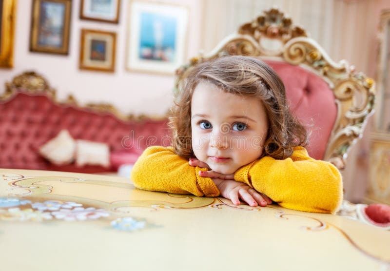 Ni?o de la muchacha en una sala de estar con la decoraci?n barroca fotografía de archivo Ni?o de la muchacha en una sala de estar con la decoraci?n barroca fotografía de archivo