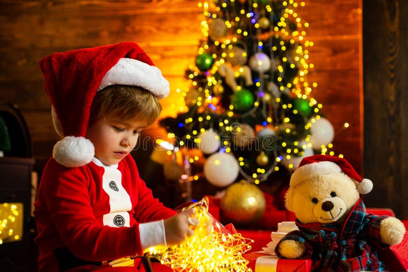 Ni?o del muchacho de Pap? Noel peque?o celebrar la Navidad en casa D?a de fiesta de la familia Juego alegre del humor del niño li fotografía de archivo libre de regalías Ni?o del muchacho de Pap? Noel peque?o celebrar la Navidad en casa D?a de fiesta de la familia Juego alegre del humor del niño li fotografía de archivo libre de regalías