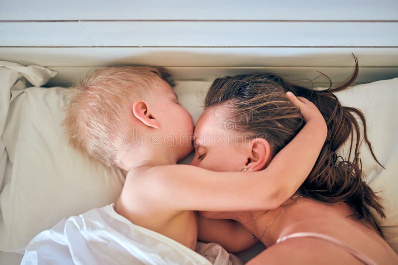 Three year old toddler boy sleeping on pillow with mother. Three year old toddler boy sleeping on pillow with mother