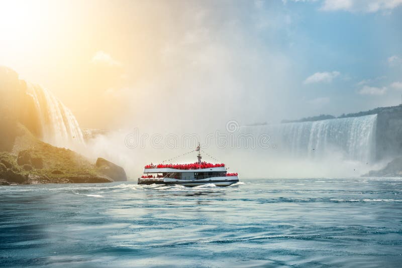 Niagara Falls boat tours attraction. Tourist people sailing on the travel boat close to the Niagara Horseshoe Fall at sunny hot su