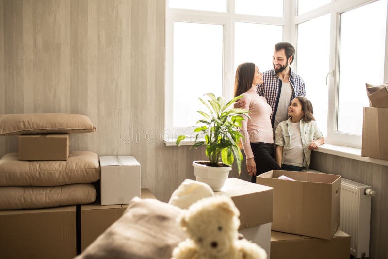 Nice en heldere flat De jonge en gelukkige familie heeft zich enkel het bewegen in het Er zijn dozen overal met hun materiaal stock afbeelding Nice en heldere flat De jonge en gelukkige familie heeft zich enkel het bewegen in het Er zijn dozen overal met hun materiaal stock afbeelding