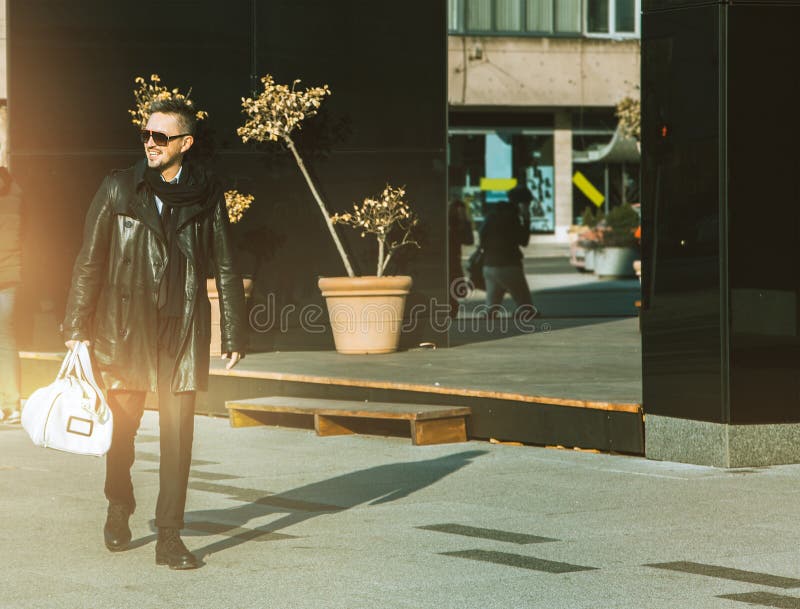 Nice man in sunglasses looking and smiling away on street stock photo Nice man in sunglasses looking and smiling away on street stock photo