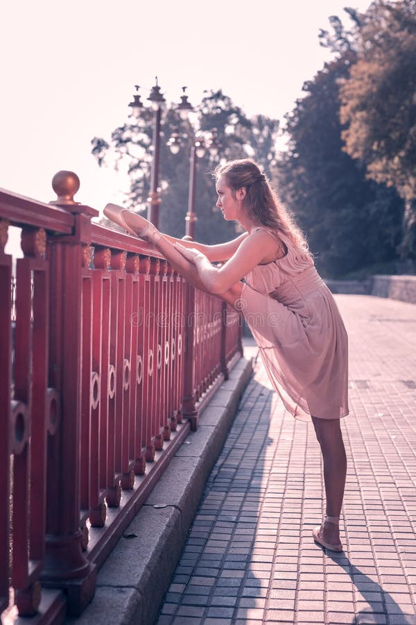 Nice positive young woman developing her flexibility