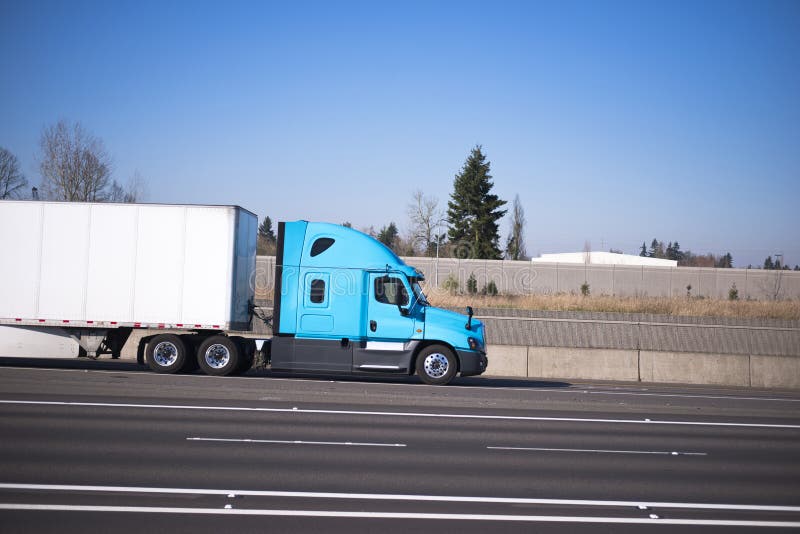 Nice profile semi truck blue green dry van trailer on multy-lines road