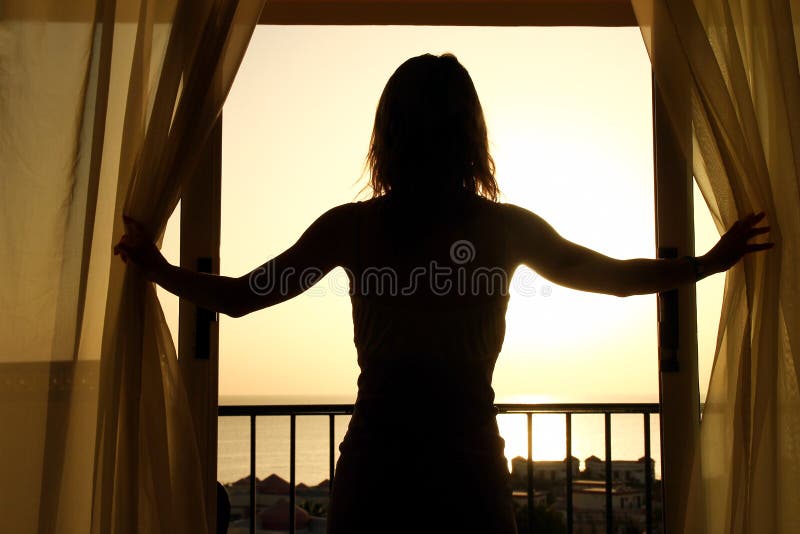 Silhouette of a women near the window on hotel