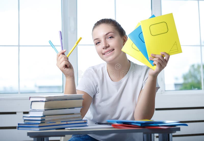 Nice teenager teen girl student is sitting at the table with boo stock photos Nice teenager teen girl student is sitting at the table with boo stock photos