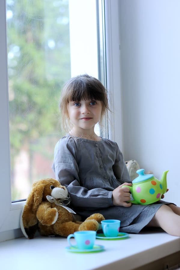 Nice toddler girl with toy tea set and bunny