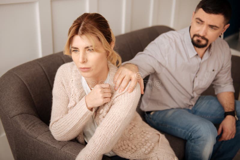 Nice uppsökte mannen som sätter hans hand på wifesskuldran royaltyfria bilder Nice uppsökte mannen som sätter hans hand på wifesskuldran royaltyfria bilder