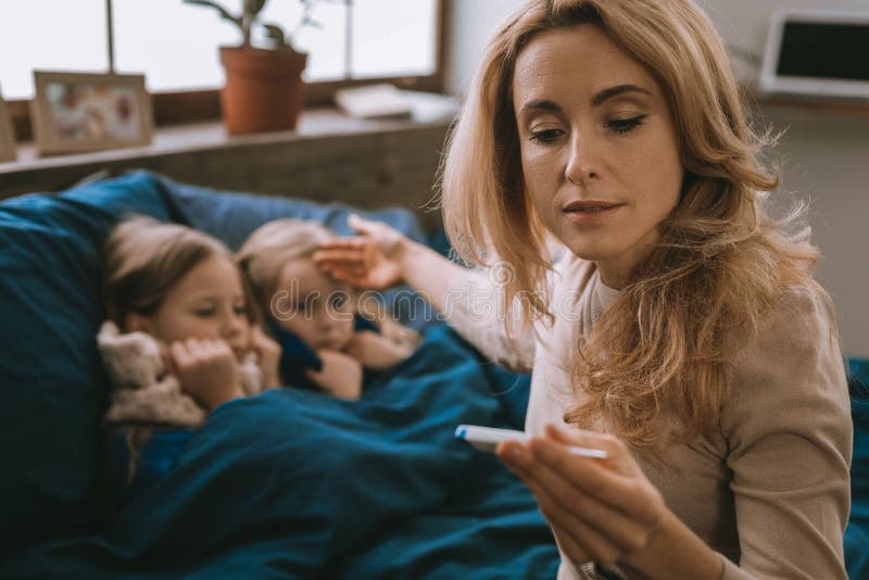 Nice worried mother looking after her sick daughters royalty free stock photos Nice worried mother looking after her sick daughters royalty free stock photos