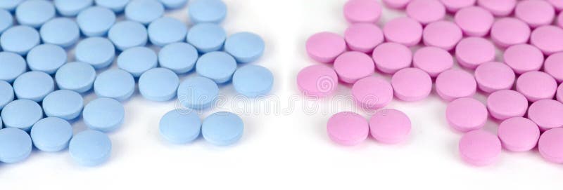 Niebieskie i różowe tabletki na białym tle