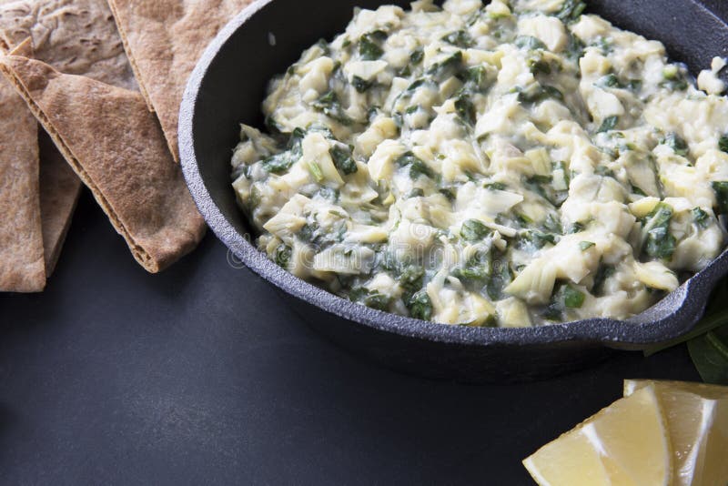 Pan with fresh vegan spinach artichoke dip and whole wheat pita bread. Pan with fresh vegan spinach artichoke dip and whole wheat pita bread