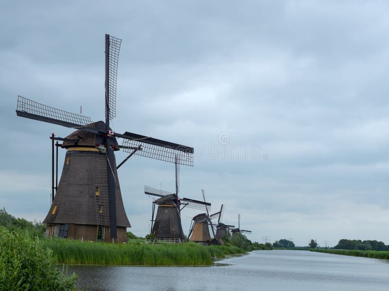 Niederländische Windmühlen nahe kleinem Fluss in Kinderdijk lizenzfreie stockbilder Niederländische Windmühlen nahe kleinem Fluss in Kinderdijk lizenzfreie stockbilder
