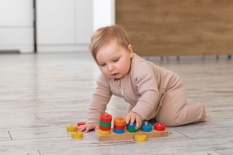 Niedliches Babyspiel mit hölzernen Schulspielzeug zu Hause. Montessori-Materialien für die Entwicklung von Kindern. selektiv lizenzfreies stockbild
