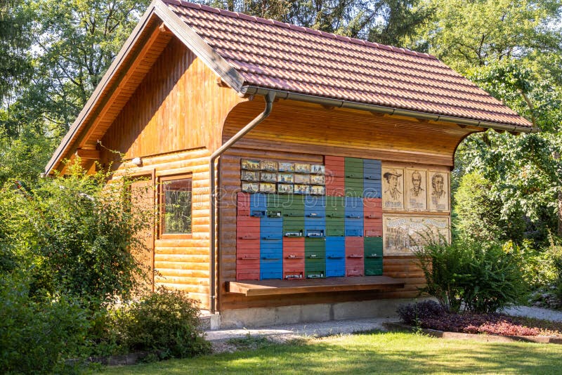 Niedliches Bienenhaus aus Holz mit einem grünen Hof mit Kiefern in Mozirje slovenia stockfotos