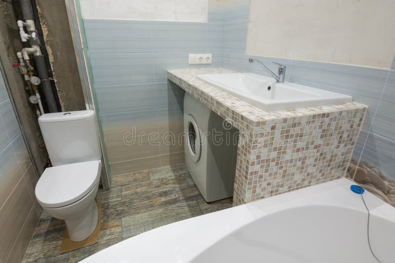 Niedokończone naprawy w łazience, piedestale pod washbasin i toaletowym pucharze, pralka pod którym jest tam