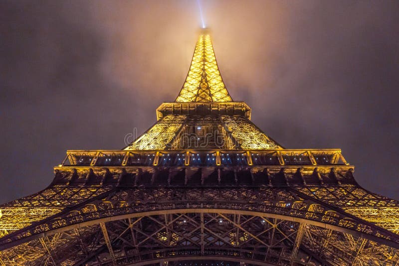 Niedrige Winkelsicht des Eiffelturms mit den Lichtern während des Abends in Paris in Frankreich lizenzfreie stockfotografie