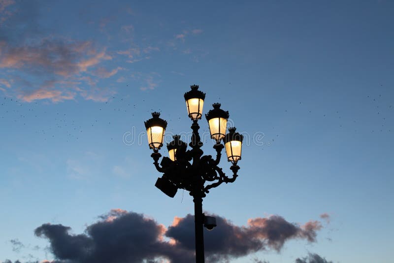 Niedrige Winkelsicht einer Straßenlampe unter einem dunklen Himmel während des Sonnenuntergangs am Abend stockfotografie