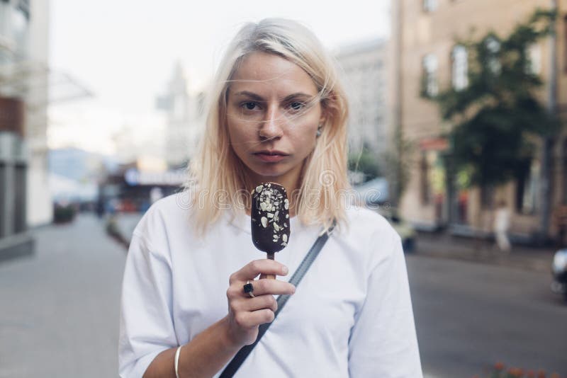 Niekonwencjonalna ładna dziewczyna je lody zdjęcie stock Niekonwencjonalna ładna dziewczyna je lody zdjęcie stock
