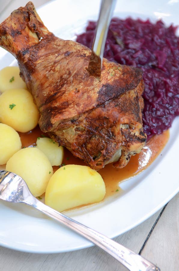 Niemiec Eisbein z braised kapustą, sałatką i piwem, piec wieprzowina knykieć (Sauerkraut) wywoławczy Schweinshaxe, Haxe, Bawarski fotografia stock Niemiec Eisbein z braised kapustą, sałatką i piwem, piec wieprzowina knykieć (Sauerkraut) wywoławczy Schweinshaxe, Haxe, Bawarski fotografia stock