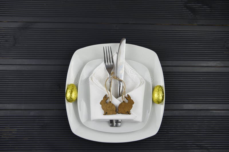 Nieociosany Wielkanocny miejsca położenie z białym crockery na ciemnym drewno stole z królika królika kształta drewnianymi dekora obrazy royalty free Nieociosany Wielkanocny miejsca położenie z białym crockery na ciemnym drewno stole z królika królika kształta drewnianymi dekora obrazy royalty free