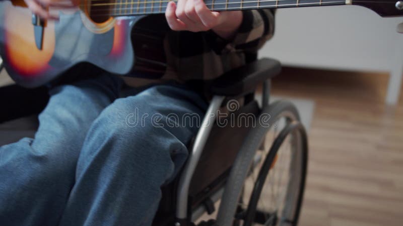 Niepełnosprawny człowiek gra na gitarze i śpiewa piosenki profesjonalnie
