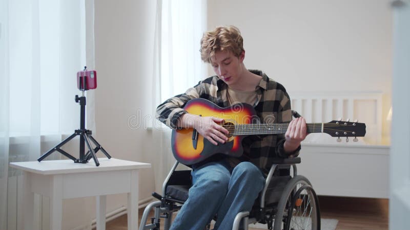 Niepełnosprawny człowiek uczy, jak zawodowo grać na gitarze